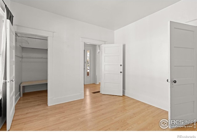 unfurnished bedroom with light wood-type flooring and a closet