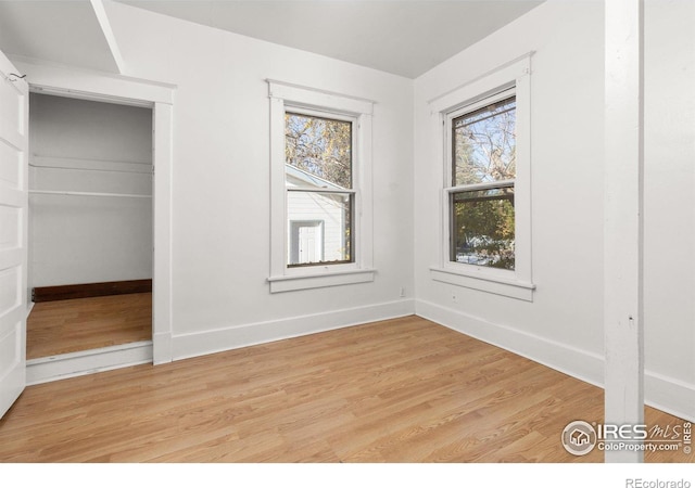 unfurnished bedroom with light wood-type flooring and multiple windows