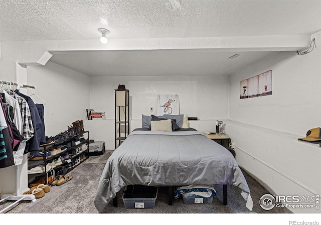 bedroom with carpet and a textured ceiling