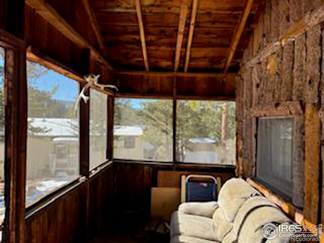 unfurnished sunroom with plenty of natural light and wooden ceiling