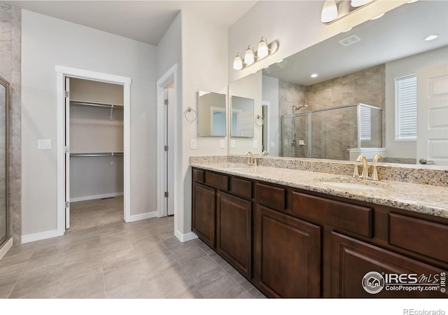 bathroom featuring tile patterned flooring, vanity, and walk in shower