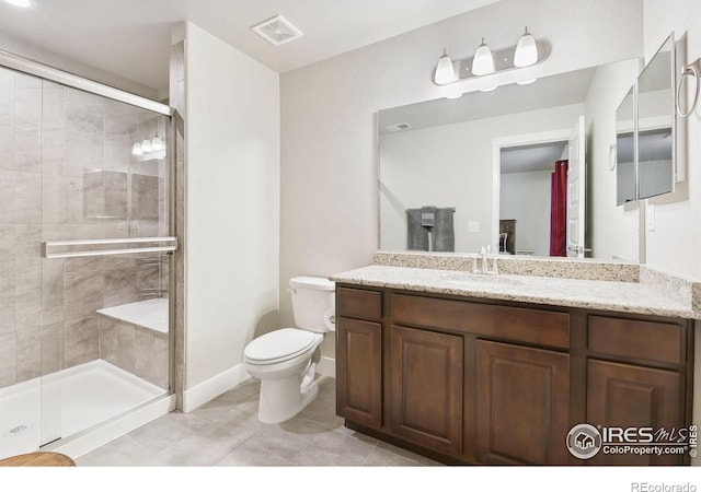 bathroom featuring tile patterned flooring, vanity, toilet, and walk in shower