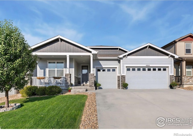 craftsman inspired home with a garage, a front yard, and a porch