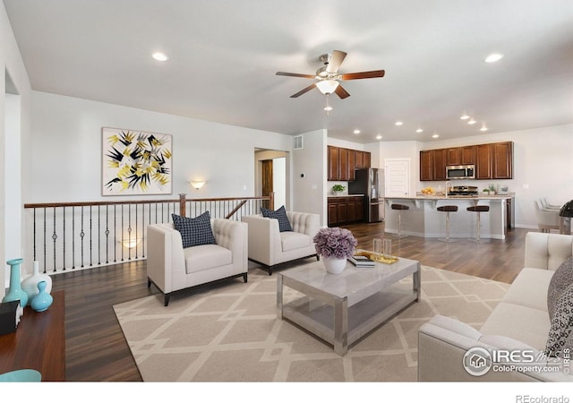 living room with ceiling fan and light wood-type flooring