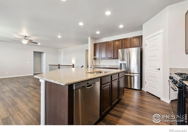 kitchen with an island with sink, appliances with stainless steel finishes, dark wood-type flooring, a sink, and recessed lighting