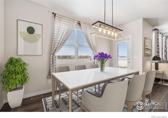 dining room with baseboards, visible vents, and dark wood-style flooring