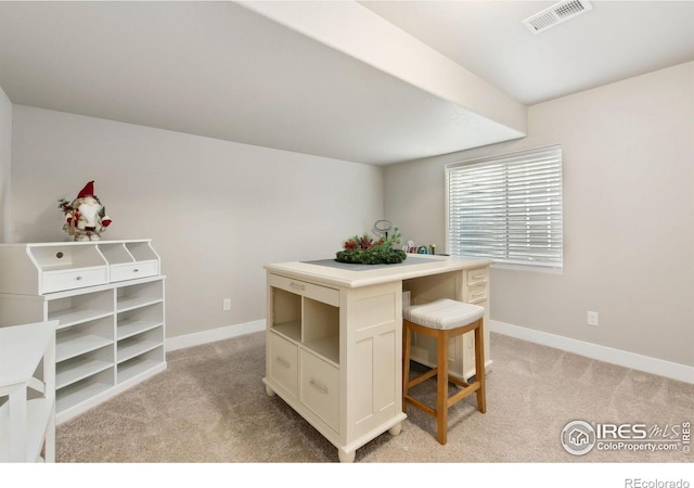 dining area featuring baseboards, visible vents, and light colored carpet