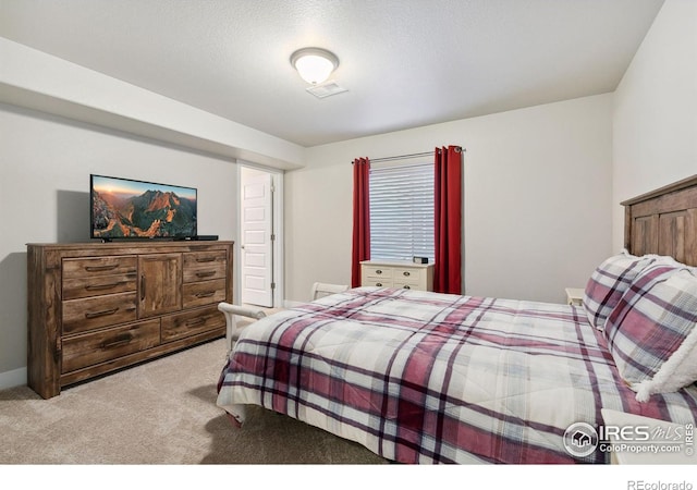 bedroom featuring carpet, a textured ceiling, visible vents, and baseboards