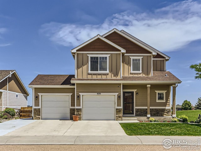 craftsman-style home featuring covered porch, a garage, and a front lawn