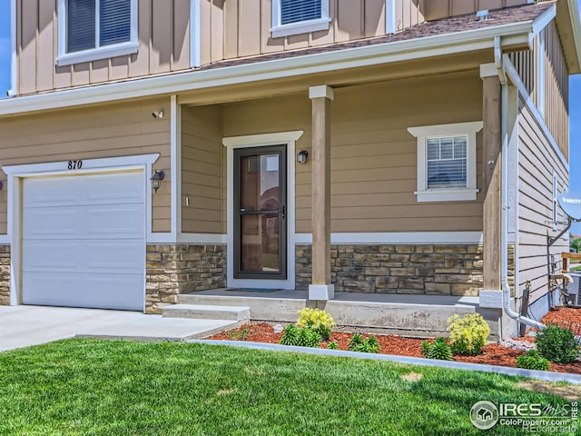 entrance to property featuring a porch and a garage