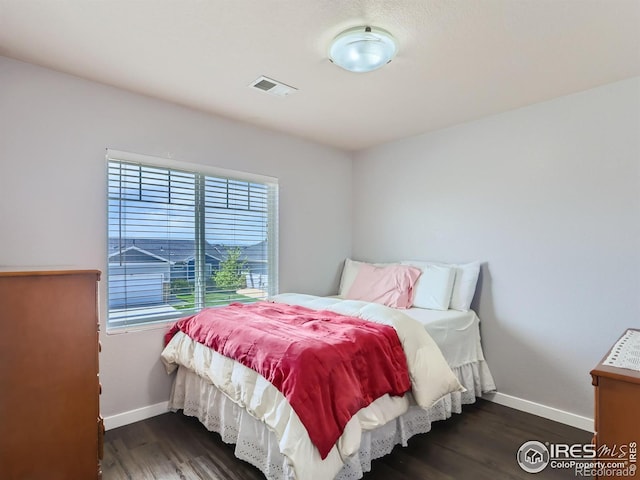 bedroom with dark wood-type flooring