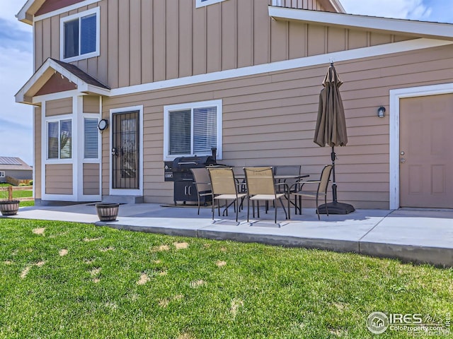 back of property with a lawn and a patio