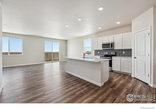 909 Harvard St, Johnstown, CO 80534 - kitchen with a sink, appliances with stainless steel finishes, white cabinets, and dark wood finished floors