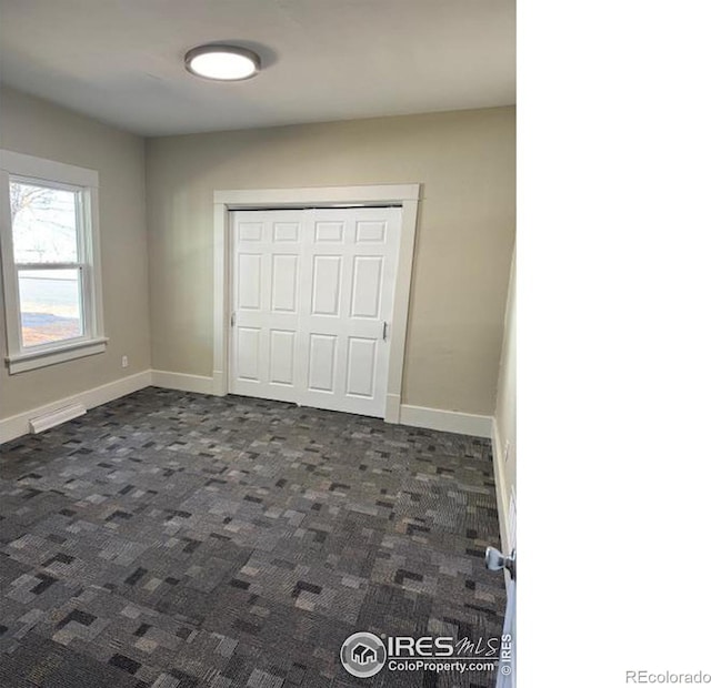 unfurnished bedroom featuring dark colored carpet