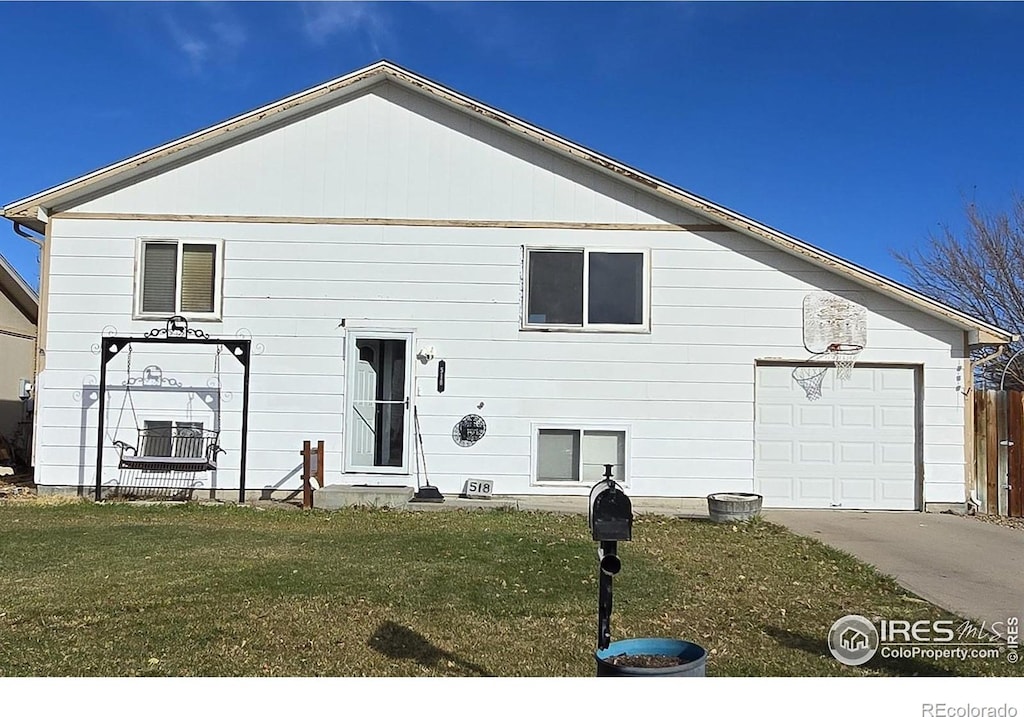 rear view of property with a lawn and a garage