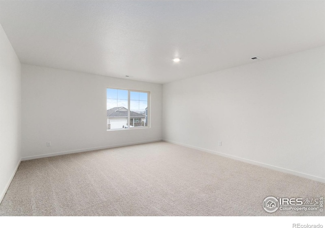 unfurnished room featuring light colored carpet