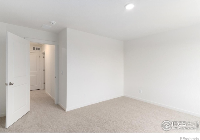 spare room featuring light colored carpet