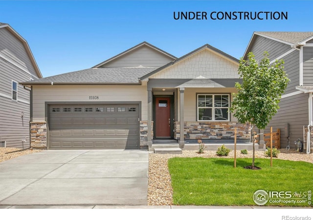 craftsman inspired home featuring a garage and a front lawn