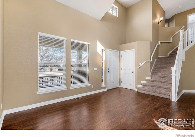 foyer with dark wood-type flooring and a high ceiling