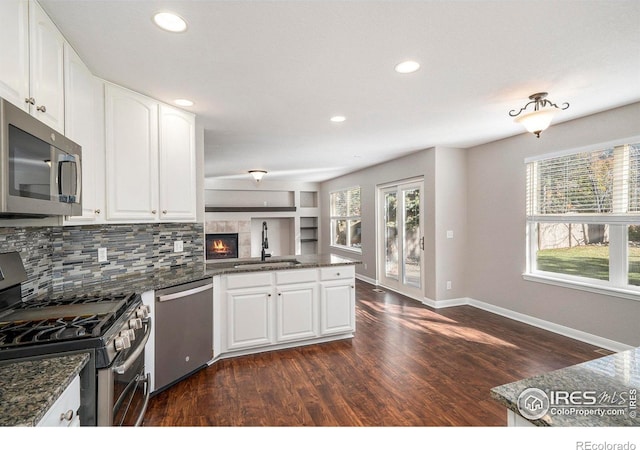 kitchen featuring white cabinetry, sink, dark wood-type flooring, and appliances with stainless steel finishes