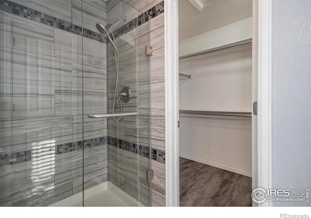 bathroom with a shower with door and hardwood / wood-style flooring