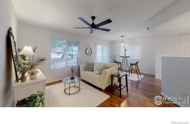 living room featuring ceiling fan and dark wood-type flooring