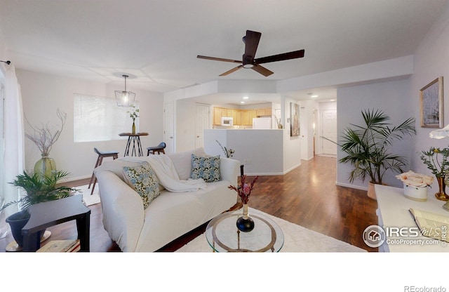 living room with ceiling fan and dark hardwood / wood-style floors