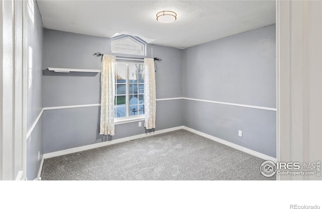 carpeted empty room with a textured ceiling