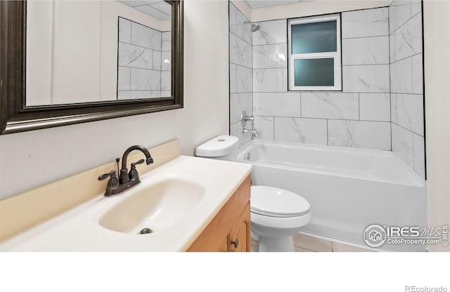 full bathroom with tile patterned floors, vanity, tiled shower / bath combo, and toilet