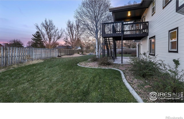 yard at dusk with a patio area and a deck