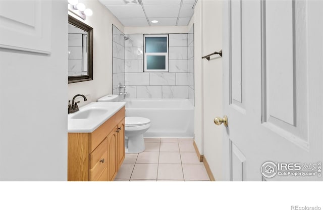 full bathroom featuring a drop ceiling, tiled shower / bath combo, tile patterned flooring, toilet, and vanity