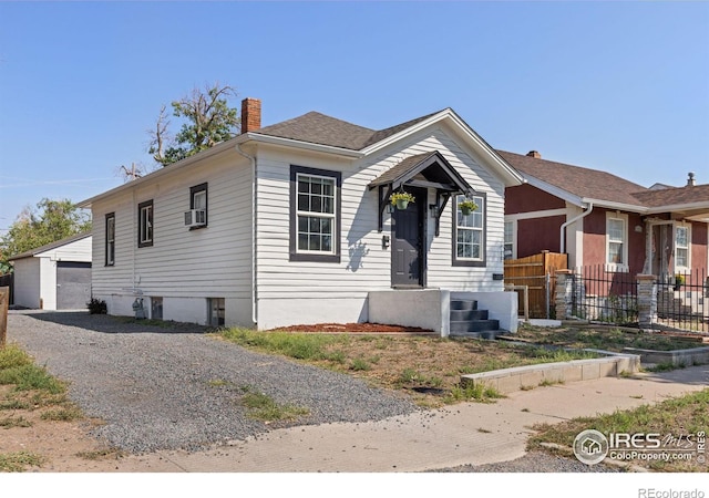 view of front of property featuring an outbuilding, a garage, and cooling unit