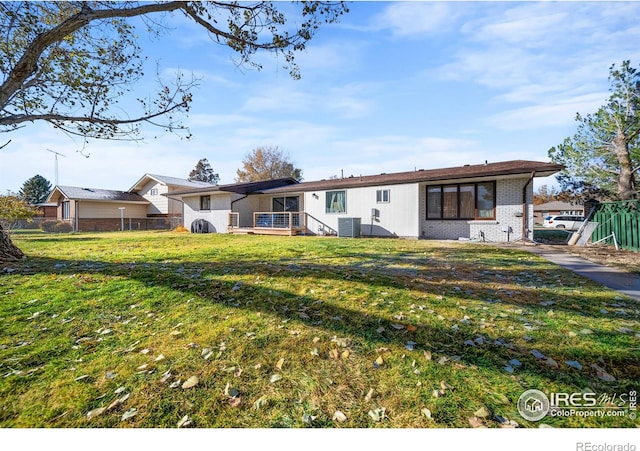 back of house featuring a lawn and central AC unit