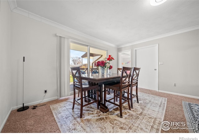 carpeted dining area featuring crown molding