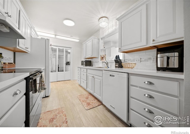 kitchen with decorative backsplash, stainless steel electric stove, dishwasher, light hardwood / wood-style floors, and white cabinetry