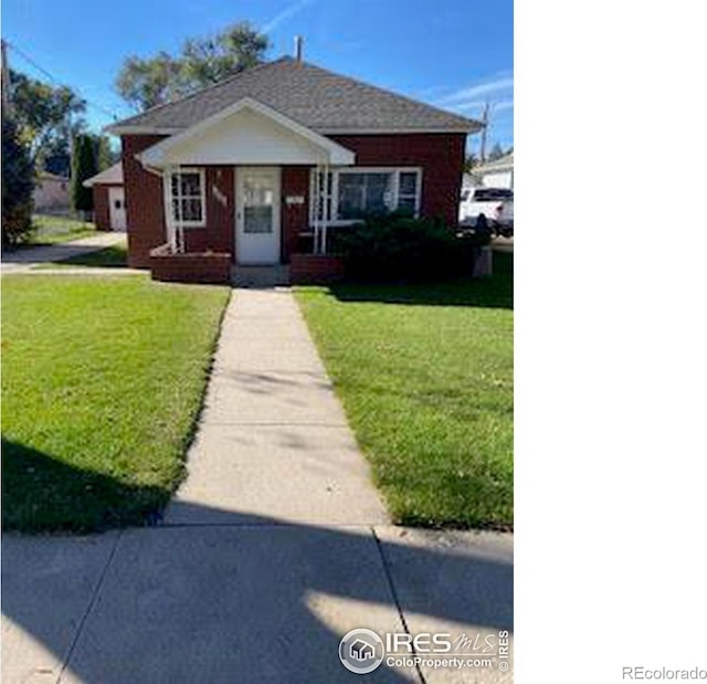 bungalow-style house featuring a front lawn