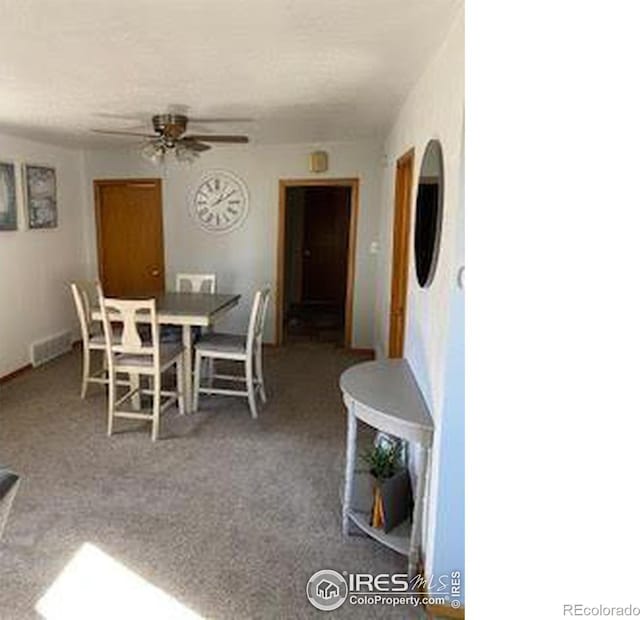 carpeted dining area with ceiling fan