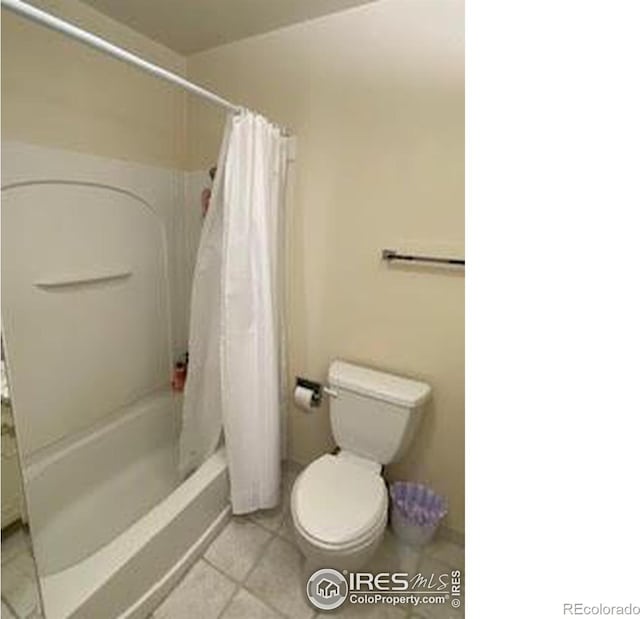 bathroom featuring shower / bath combo with shower curtain, tile patterned flooring, and toilet