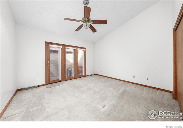 spare room featuring lofted ceiling, baseboards, visible vents, and light colored carpet