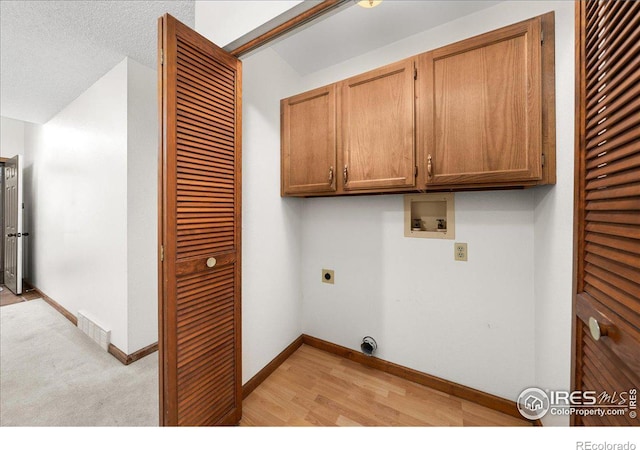 washroom with cabinet space, baseboards, visible vents, washer hookup, and electric dryer hookup