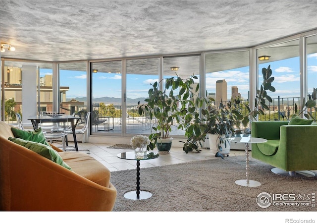 tiled living room with a mountain view, a wall of windows, and plenty of natural light