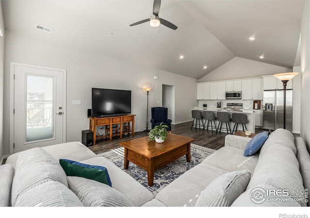 living room with dark hardwood / wood-style flooring, vaulted ceiling, and ceiling fan