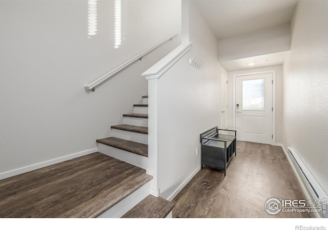 staircase featuring a baseboard radiator and hardwood / wood-style flooring