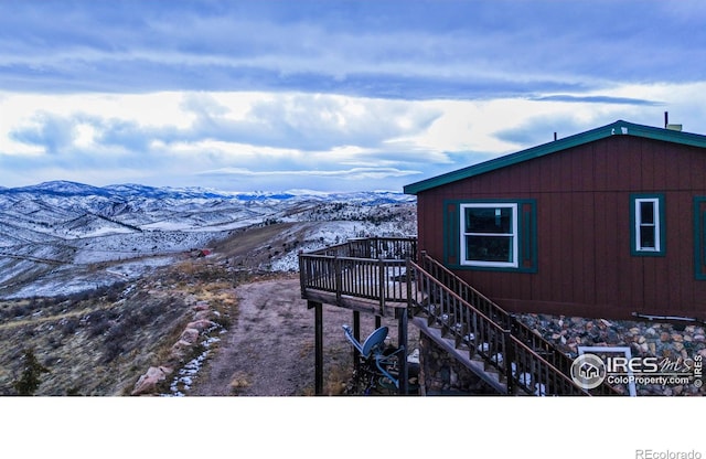 view of snow covered exterior with a deck with mountain view