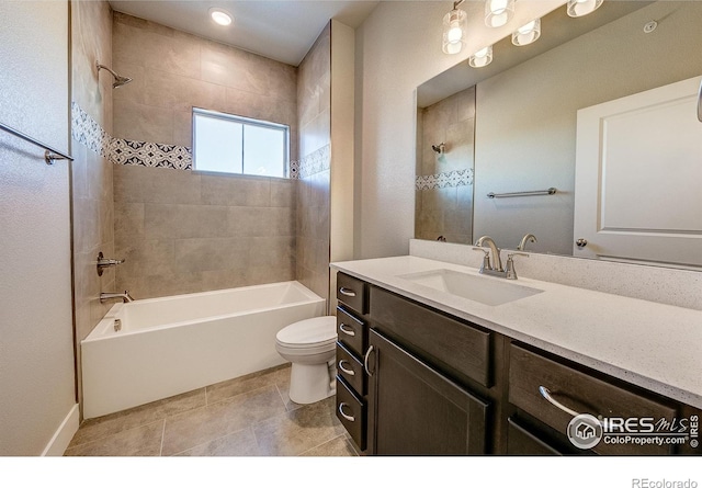 full bathroom featuring vanity, tiled shower / bath combo, toilet, and tile patterned flooring