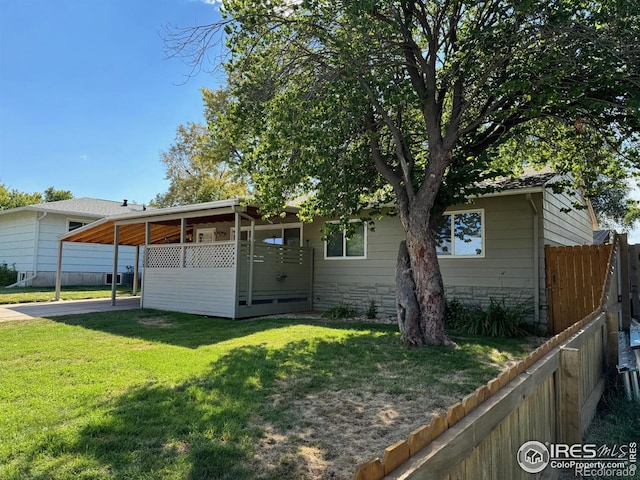 rear view of property featuring a yard and a carport