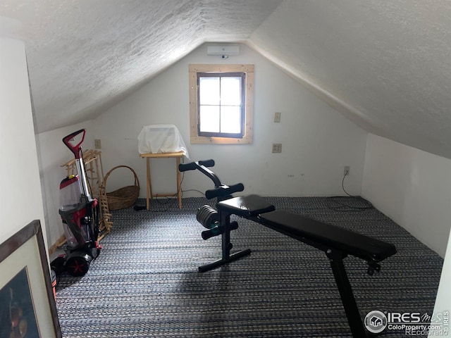 workout room featuring a textured ceiling, carpet floors, and lofted ceiling