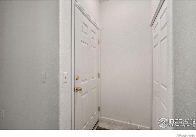 entryway with baseboards and light tile patterned flooring