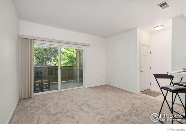 interior space featuring light carpet, visible vents, and baseboards