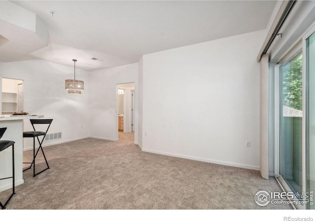 empty room featuring baseboards, visible vents, and light colored carpet